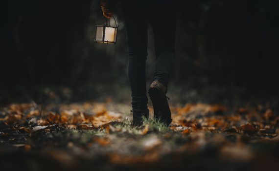 Man walking with a lantern in a woods